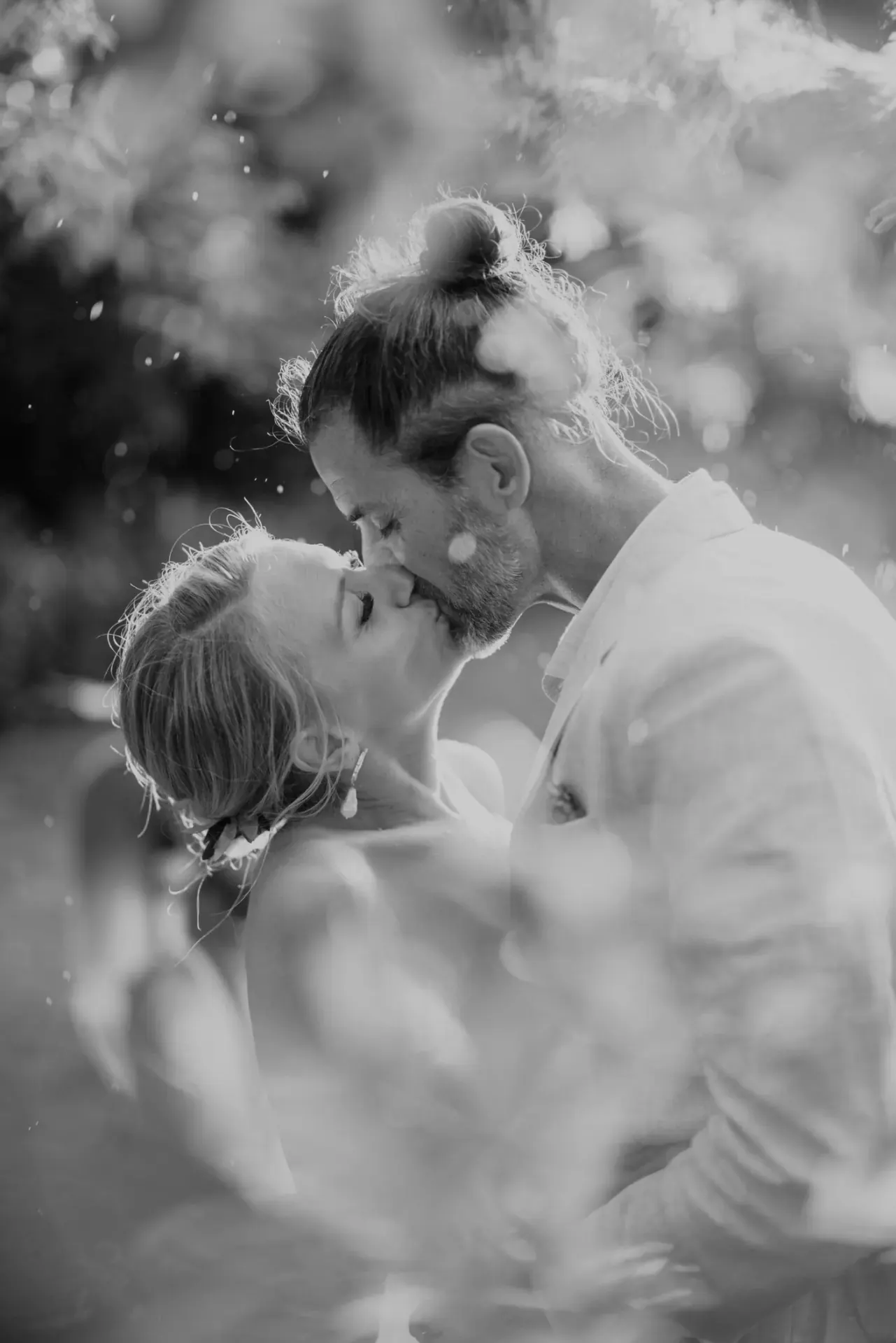 Bacio di matrimonio in bianco e nero tra le foglie